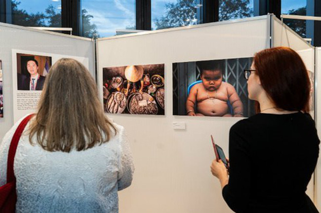 Two visitors look at photos on display at the “Mexico - Vietnam: At the Crossroads of Vietnam” exhibition in HCMC - Photo: Courtesy of Honorary Consulate of Mexico in HCM City