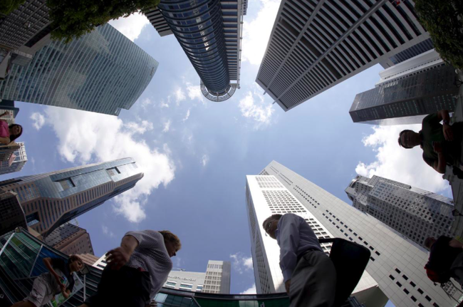 People walk past office buildings at the central business district in Singapore April 14, 2015. (Photo: REUTERS/Edgar Su)