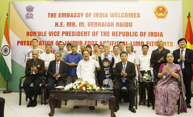 Indian Vice President Venkaiah Naidu (first row, in white) poses for a photo together with patients of new Jaipur Foot Artificial Limb Fitment Camps in Quang Ninh and Yen Bai provinces (Photo: VNA)
