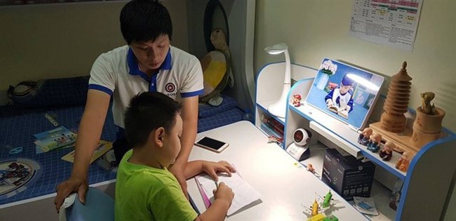 A Virobo staff helps a boy try out a Captain Eye robot (Photo courtesy of Virobo)