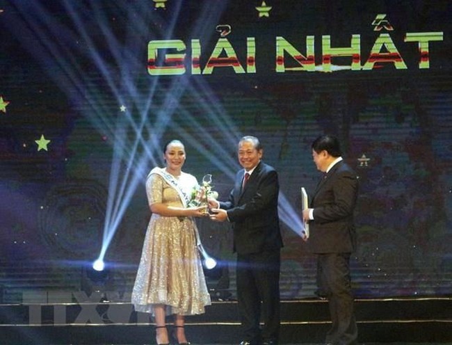 Deputy Prime Minister Truong Hoa Binh (C) presents first prize to Malaysian singer Rosario Ninih Chamini Bianis (Source: VNA)