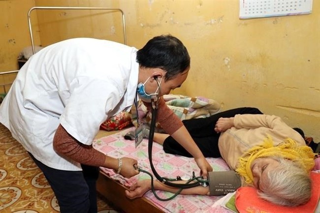 A doctor measures the blood pressure of an elderly woman at the Centre for Social Protection of Hai Duong province (Photo: VNA)