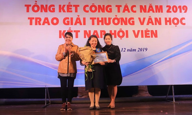 Writer Le Minh Khue (C) receives the Lifetime Literary Achievement Award from the Hanoi Writers’ Association. (Photo: Ha Noi Moi Newspaper)
