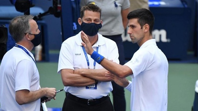 Novak Djokovic discusses with a tournament official after being defaulted for striking a lines person with a ball against Pablo Carreno Busta (not pictured) on day seven of the 2020 US Open tennis tournament at USTA Billie Jean King National Tennis Centre. (Photo: USA TODAY Sports)