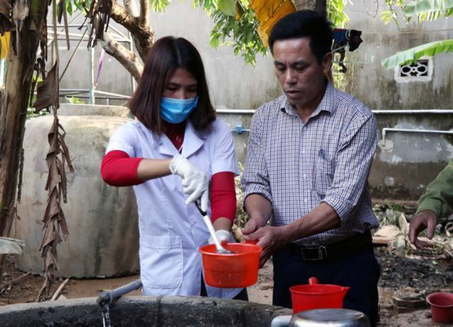 A health worker disinfects water of a well for local residents in the central province of Ha Tinh. (Photo: VNA)