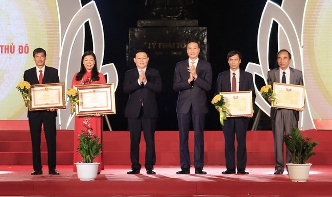 Secretary of the Hanoi Party Committee Vuong Dinh Hue (third from left) and Vice President of the VFF Central Committee Phung Khanh Tai present the certificates of merit to outstanding individuals in the city's front work.