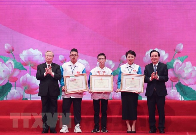 Permanent Member of the Party Central Committee’s Secretariat Tran Quoc Vuong and Minister of Education and Training Phung Xuan Nha present the first prizes of the contest “Youth study and follow the Ho Chi Minh thought, morality and lifestyle”. (Photo: VNA)