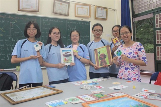 Nguyen Tran Quynh Phuong (right, first), a chemistry teacher at Nguyen Huu Huan High School, Thu Duc District, and her students show off some of the paper and hand-made souvenirs made from bagasse. (Photo thanhnien.vn)