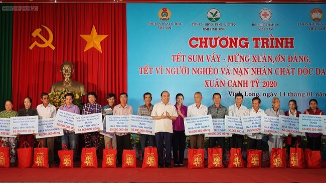 Prime Minister Nguyen Xuan Phuc (central) presents gifts to poor people at the programme (Photo: VGP)
