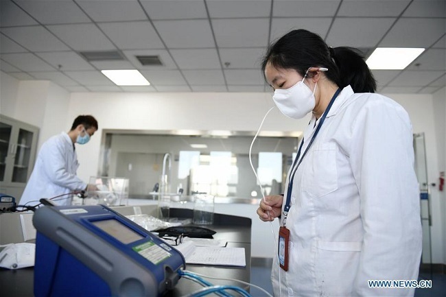 An inspector tests the leakproofness of a protective mask sample at a laboratory of Shaanxi Institute of Medical Device Quality Supervision and Inspection in Xi'an, capital of northwest China's Shaanxi Province, Feb. 16, 2020. (Photo: Xinhua)