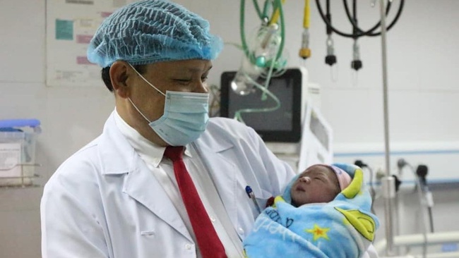 Associate Professor Tran Danh Cuong holds the first baby born in 2020 in his arms.