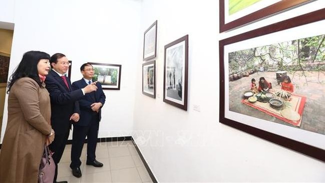 Visitors admire paintings on display at the exhibition (Photo: VNA)