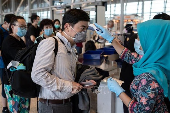 Passengers undergo temperature check in an airport in Kuala Lumpur, Malaysia (Photo: VNA)