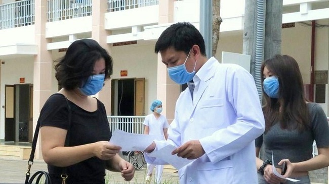 A doctor giving the hospital discharge document to a patient who has recovered from the COVID-19 disease in Ho Chi Minh City’s Cu Chi District on March 30, 2020. (Photo: VNA)