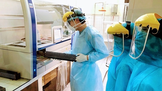 Health workers in Hai Phong City operate an automatic Real time RT-PCR molecular biology machine to serve COVID-19 testing. (Photo: NDO/Ngo Quang Dung)