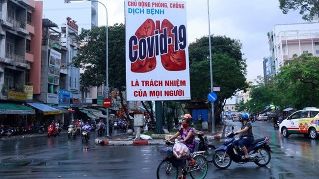 Motorbikes drive past a billboard warning against the coronavirus disease after the government eased nationwide lockdown during the outbreak in Ho Chi Minh City, Vietnam (Photo: Reuters)