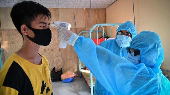 A quarantined boy has temperature checked. (Photo: VNA)