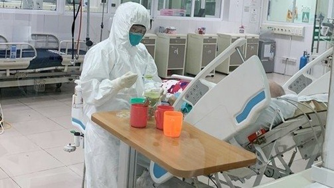 A health worker provides intensive care to a COVID-19 patient at the National Hospital of Tropical Diseases in Hanoi.