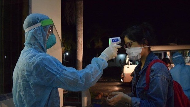 A woman has temperature checked (Photo: VNA)