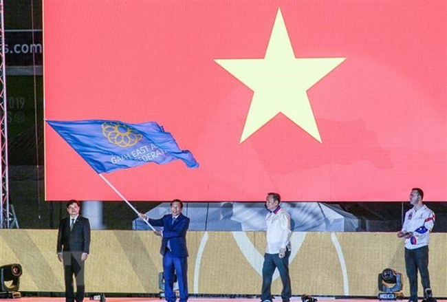 Minister of Culture, Sports and Tourism Nguyen Ngoc Thien receives the flag for the next hosting of the SEA Games 31 and ASEAN Para Games 11 at the closing ceremony of SEA Game 30 in the Philippines on December 11, 2019 (Photo: VNA)