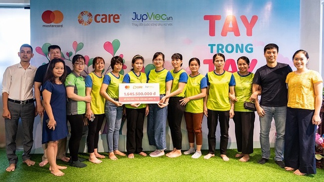 Female workers receive a token representing the VND1.6 billion of financial support for them at an event held in Hanoi on June 12, 2020.