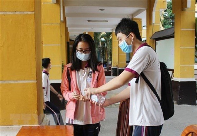 Students clean their hands with sanitiser before entering classrooms (Photo: VNA)