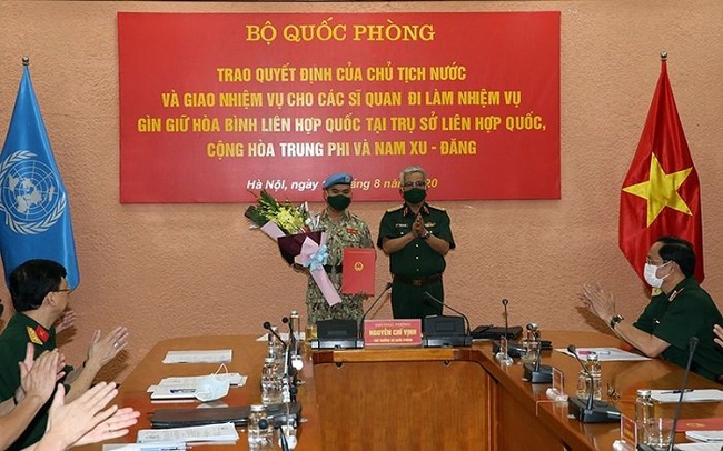 Deputy Minister of Defence Sen. Lieut. Gen. Nguyen Chi Vinh hands over the President's decision to the officers.
