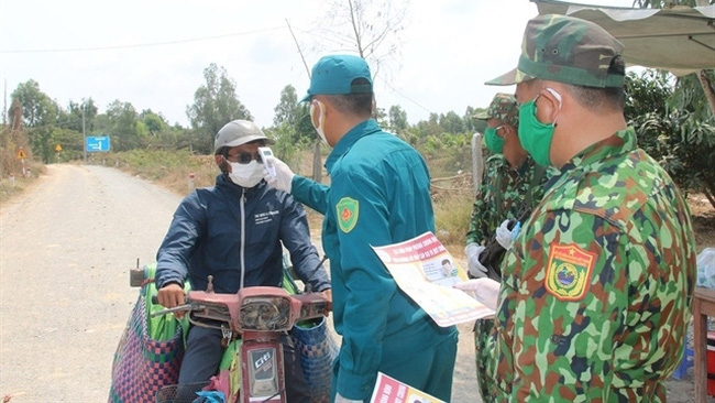 A driver has body temperature taken at a checkpoint manned by border guards in the southern province of Dong Thap. (Photo: VNA)