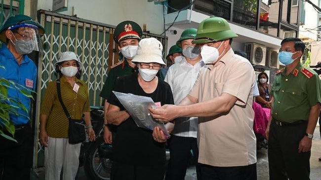Secretary of the Hanoi Municipal Party Committee Dinh Tien Dung checks the tracing logbook of the response teams for COVID-1 in the “green zone” at Lane 14 Nguyen Khuyen Street, Van Mieu Ward, Dong Da District. (Photo: NDO)