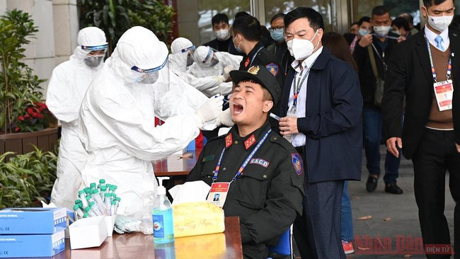 Health workers in protective suits collect nasal-throat samples from staff members at the National Convention Centre in Hanoi, where the 13th National Party Congress is taking place. (Photo: NDO)