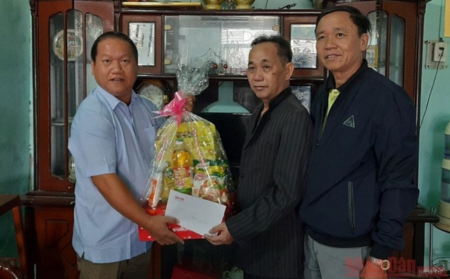 Representatives of Nhan Dan Newspaper and the Kon Tum Provincial Department of Labour, Invalids and Social Affairs present a Tet gift to war invalid Tran Van Thin.