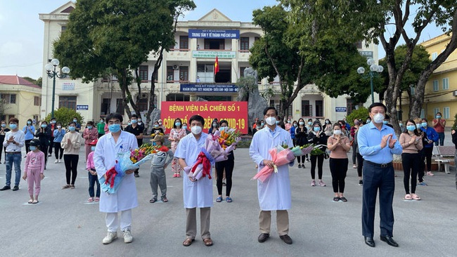 Secretary of the Hai Duong Provincial Party Committee Pham Xuan Thang (far right) presents flowers to congratulate doctors and recovered COVID-19 patients discharged from hospital on February 21, 2021. (Photo: NDO/Quoc Vinh)