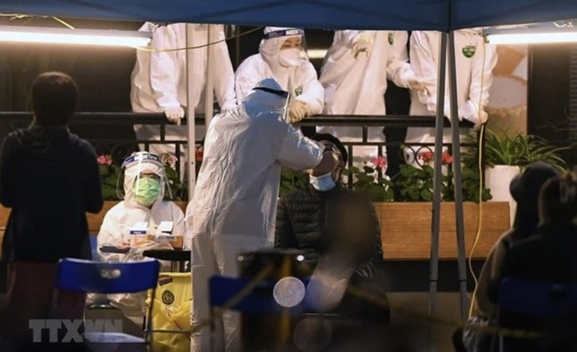 Medical workers take samples from residents at an apartment building in Hanoi for COVID-19 testing (Photo: VNA)