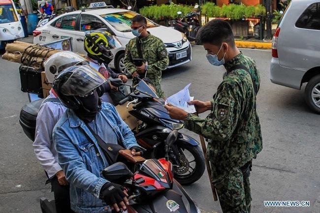 Policemen work at a checkpoint in Manila, the Philippines on March 10, 2021. (Photo: Xinhua)