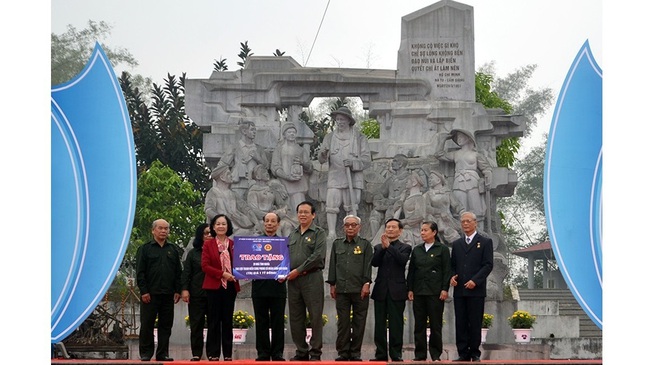 Politburo member Truong Thi Mai (in red coat) presents 20 houses of gratitude to the Vietnam Former Youth Volunteers’ Association. (Photo: NDO)