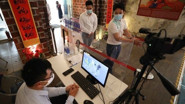 People have their body temperature checked and sanitise their hands when visiting Thang Long Imperial Citadel on March 8 (Photo: VNA)
