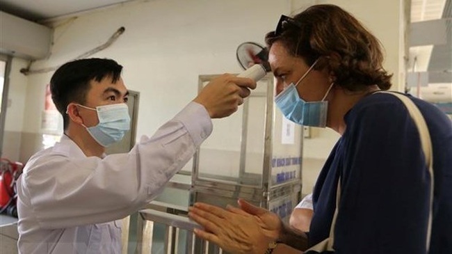 A passenger has body temperature checked before coming into a bus station in Hanoi (Photo: VNA)