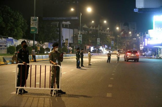 Police keep watch on a Phnom Penh street as COVID-19 preventive measures are in place (Photo: Xinhua/VNA)