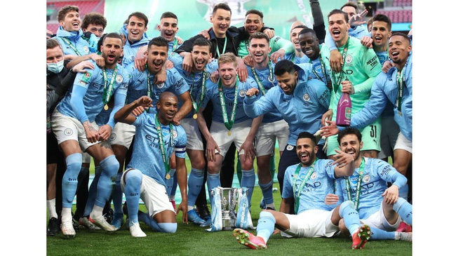 Manchester City players pose with the trophy as they celebrate after winning the Carabao Cup. (Photo: Pool via Reuters)