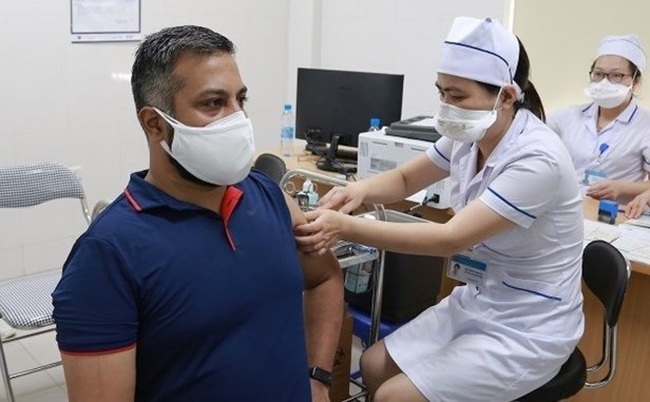 A foreign reporter gets vaccinated against COVID-19 (Photo: VNA)