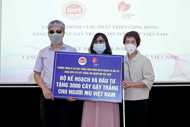 Deputy Minister of Planning and Investment Nguyen Thi Bich Ngoc (R) presents a token of 3,000 white canes to the Vietnam centre for rehabilitation training for the blind on June 22. (Photo: baodautu.vn)