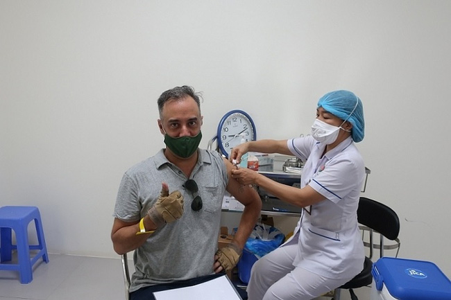 Simon H. Roy, a risk management advisor for the STEP project, Devéloppement International Desjardins - DID (Canada), is being administered a COVID-19 vaccine dose. (Photo: dangcongsan.vn)