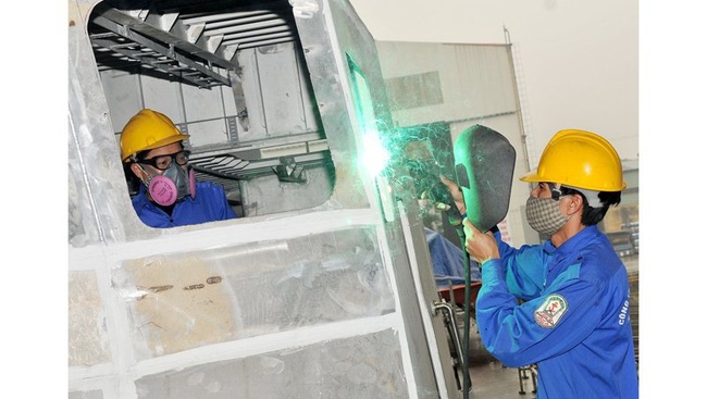 Workers at Hong Ha Shipbuilding company welding a ship hull.