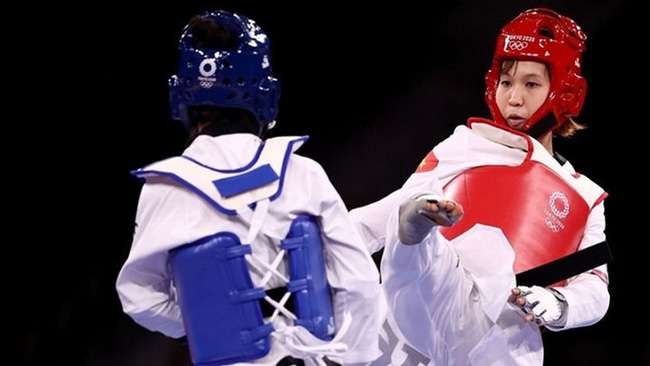 Vietnamese taekwondo artist Truong Thi Kim Tuyen (in red) competes in the women's -49kg category at the Tokyo 2020 Olympic Games.