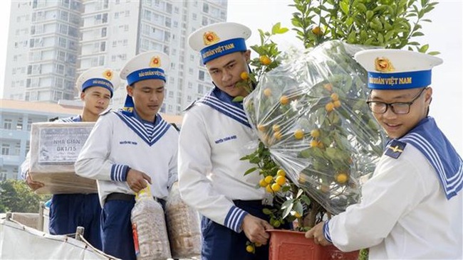 Soldiers carry gifts and goods onto the ships.(Photo: VNA)