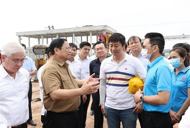 Prime Minister Pham Minh Chinh talks with investors who are implementing projects in Bau Bang Industrial Park in the southern province of Binh Duong. (Photo: VNA)