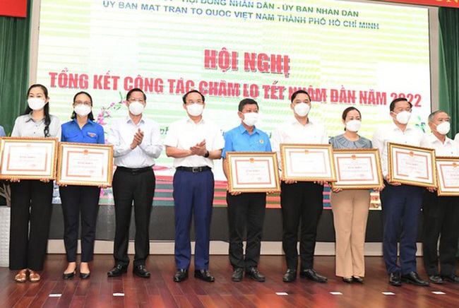 Secretary of HCMC Party Committee Nguyen Van Nen and Chairman of HCMC People’s Committee Phan Van Mai are delivering certificates of merit to groups who are excellent in Tet preparation tasks. (Photo: SGGP)