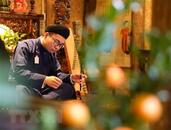 An artist plays traditional music instrument at the event. (Photo: VNA)