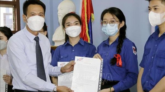 Tran Dai Thang, First Secretary of the Vietnamese Embassy in Laos, (first, on the left) presents scholarships of Ton Duc Thang University to students of Nguyen Du Lao-Vietnamese Bilingual School. (Photo: VNA)