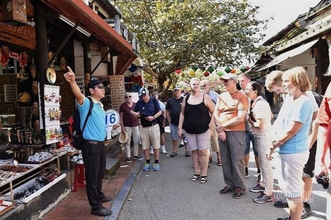 A tour guide speaking to a group of int'l tourists in Hoi An in 2019. (Photo: vietnamnet.vn)
